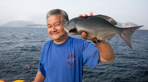 魚を持つ漁師さん